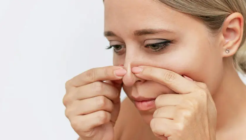 En kvinna undersöker sin näsa, där en pormask som fylls på syns tydligt.