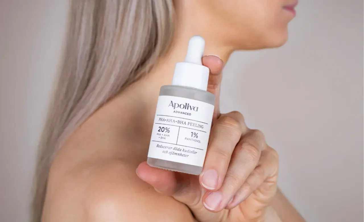 En hand håller en flaska med Apoliva PHA+AHA+BHA Peeling, perfekt för att behandla **peeling ansikte torr hy**.