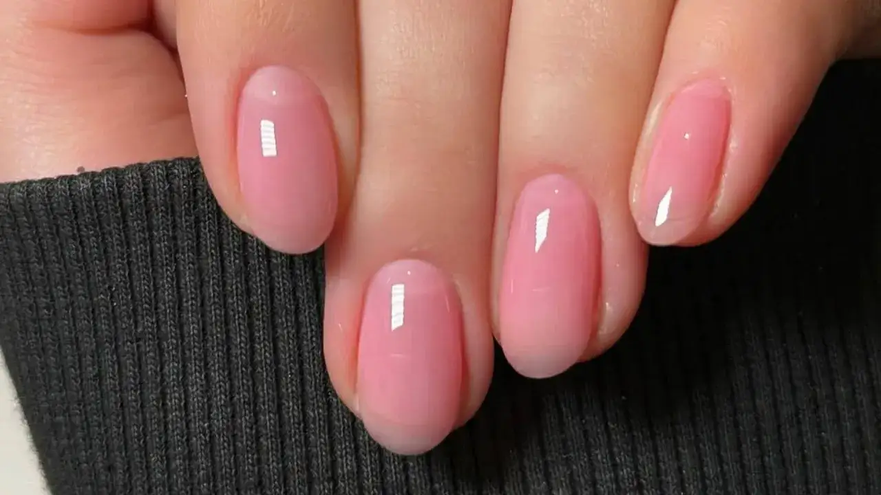 Fina, runda naglar med trind nagellack i en mjuk rosa nyans. Perfekt för en klassisk och elegant look.